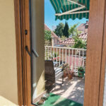Puerta acristalada de PVC imitación madera con persiana
